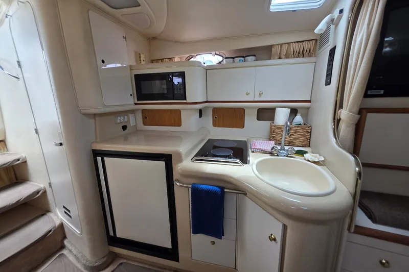 Slide: The Image of Interior of a 1999 Sea Ray Sundancer 330 yacht, featuring a compact kitchen area. - 7