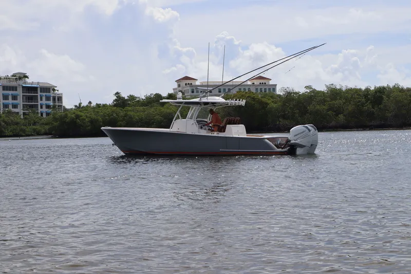 Slide: The Image of 2020 Valhalla 33 boat cruising on a calm waterway near lush greenery and buildings. - 12
