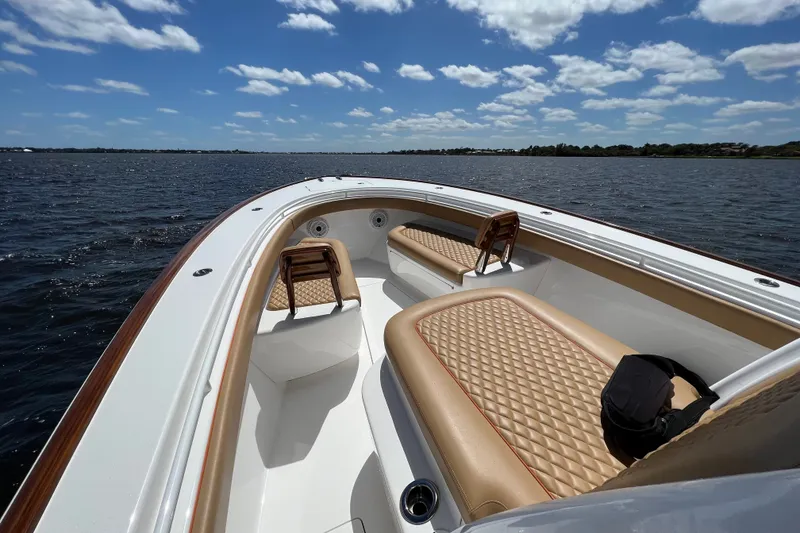 Slide: The Image of 2020 Valhalla 33 boat interior with tan diamond-stitched seating on a sunny day. - 1