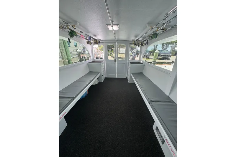 Slide: The Image of Interior of 1990 Buddy Cannady 57 Custom Carolina boat with seating and fishing rods. - 9