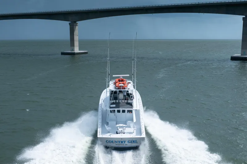 Slide: The Image of Custom Carolina 57 Buddy Cannady boat cruising under a bridge, 1990 model. - 4