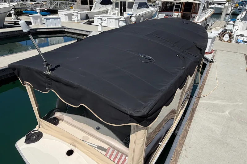 Slide: The Image of 2005 Duffy Classic 21 boat with black canopy docked at marina. - 23