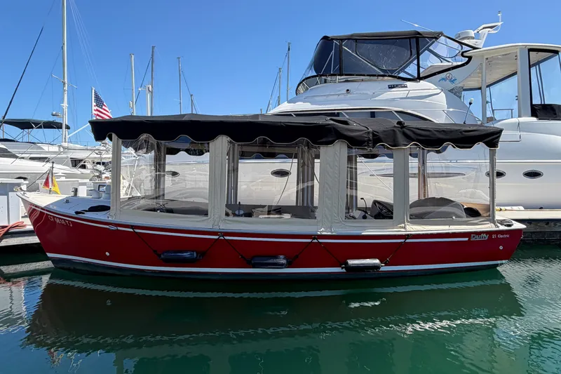 The Image of Red 2005 Duffy Classic 21 electric boat docked at marina with yachts. - 0