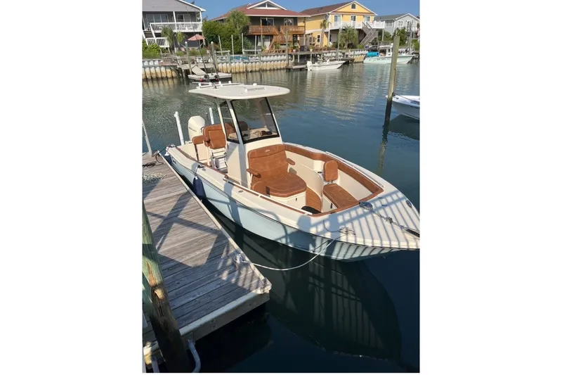 The Image of 2024 Scout 240 XSF boat docked in a serene marina setting. - 1
