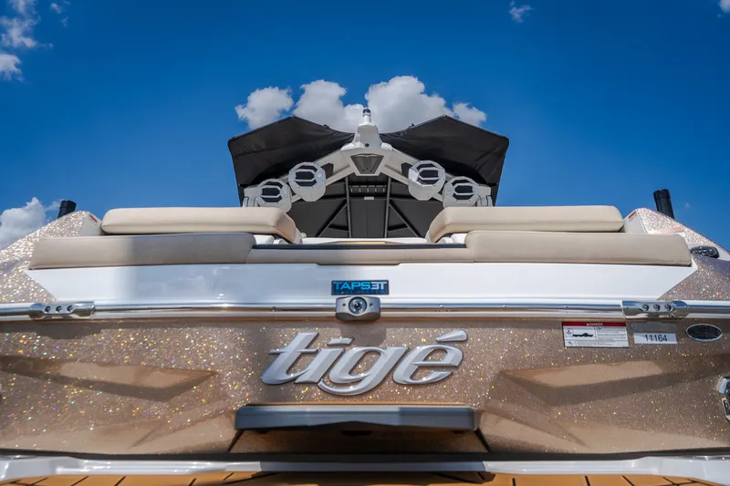 Slide: The Image of 2027 Tigé Ultré 23ZX boat rear view with sparkling finish under blue sky. - 26