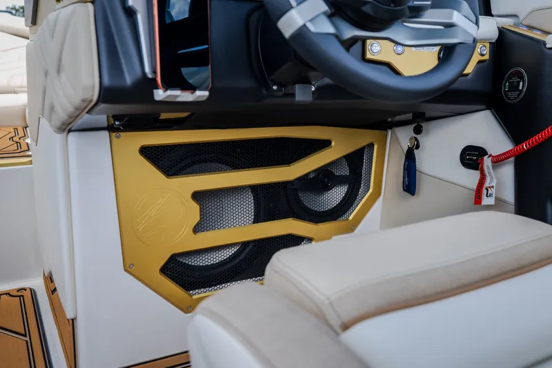 Slide: The Image of 2027 Tigé Ultré 23ZX boat interior with gold speaker detail and steering wheel. - 39