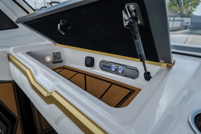 Slide: The Image of 2027 Tigé Ultré 23ZX boat interior storage compartment with controls and QR code. - 48