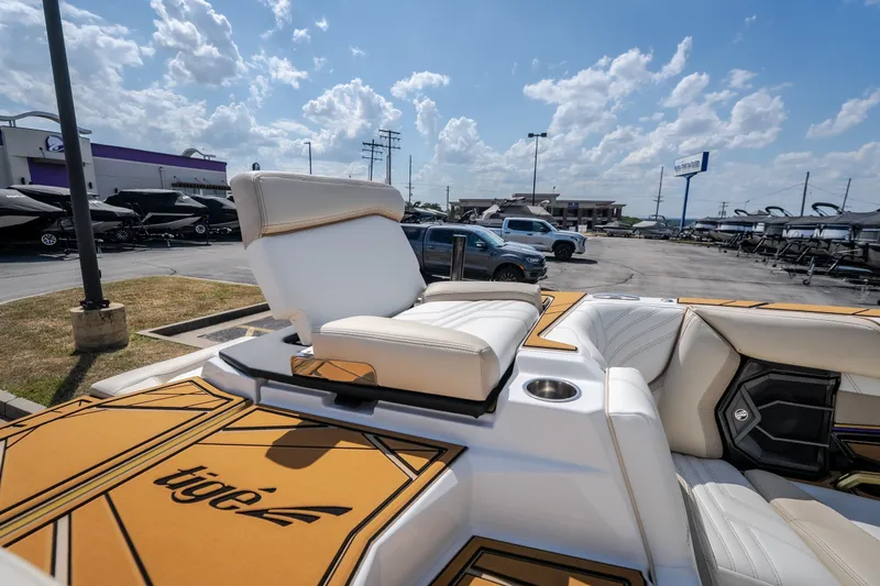 Slide: The Image of 2027 Tigé Ultré 23ZX boat interior with luxurious seating and cup holder, displayed outdoors. - 59