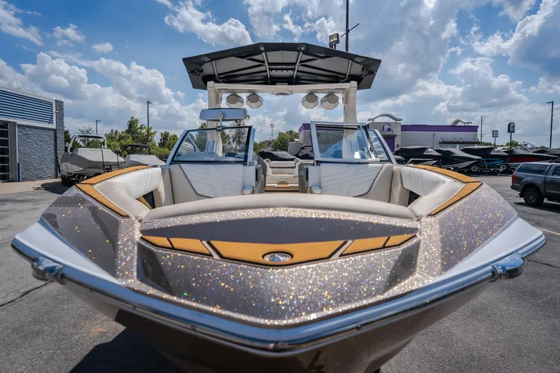 Slide: The Image of 2027 Tigé Ultré 23ZX boat with sparkling exterior, parked outdoors under a cloudy sky. - 14