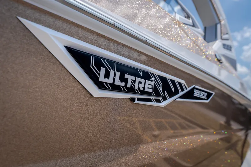 Slide: The Image of 2027 Tigé Ultré 23ZX boat emblem on a sparkling metallic finish. - 16