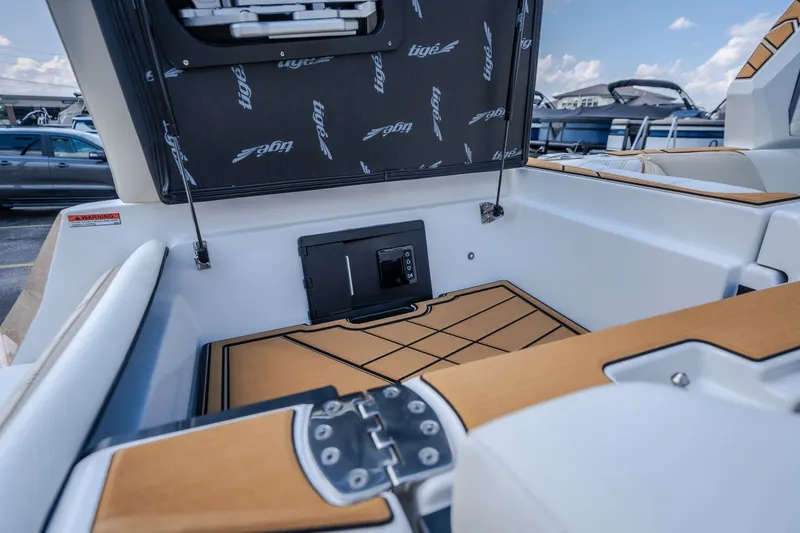 Slide: The Image of 2027 Tigé Ultré 23ZX boat interior with open storage compartment and sleek design. - 63