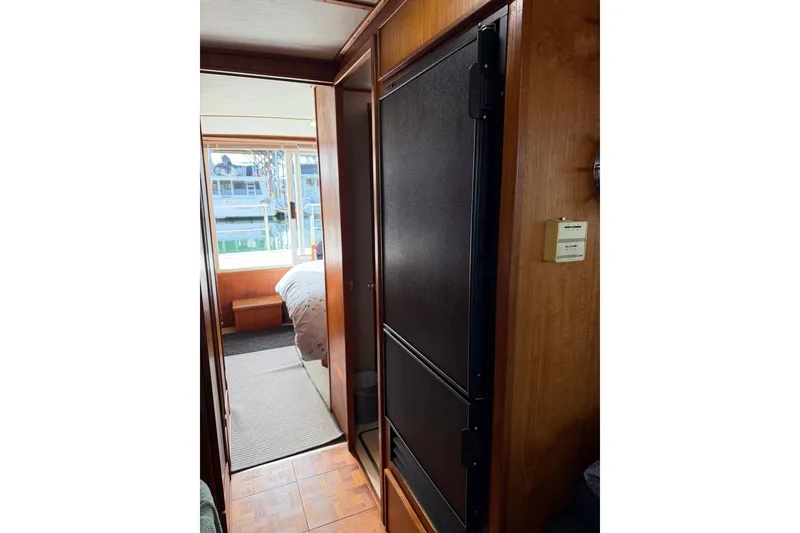 Slide: The Image of Interior view of a 1990 Cruise-A-Home Corsair boat with wood paneling and window. - 57