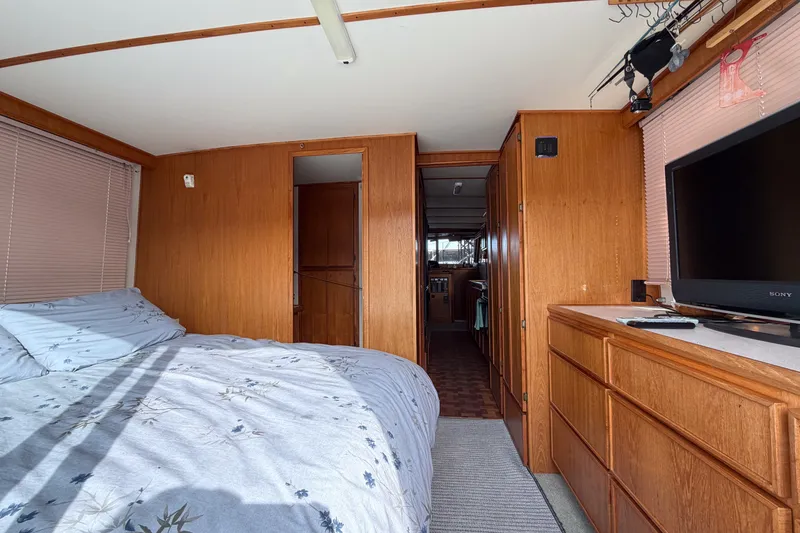Slide: The Image of Interior of 1990 Cruise-A-Home Corsair with bed, wooden cabinets, and TV. - 69