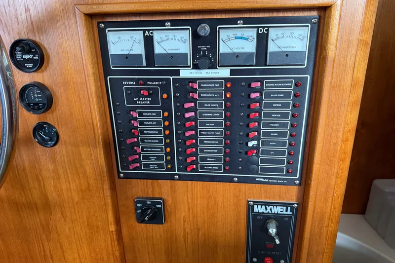 Slide: The Image of Electrical control panel on a 1990 Cruise-A-Home Corsair boat, featuring AC and DC meters. - 27