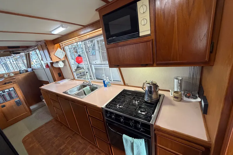 Slide: The Image of Interior of 1990 Cruise-A-Home Corsair kitchen with wooden cabinets and modern appliances. - 44