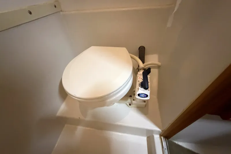 Slide: The Image of 1990 Cruise-A-Home Corsair marine toilet with manual pump in compact bathroom setting. - 66