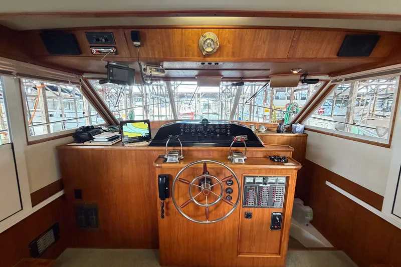 Slide: The Image of 1990 Cruise-A-Home Corsair boat helm with wooden dashboard and navigation equipment. - 46