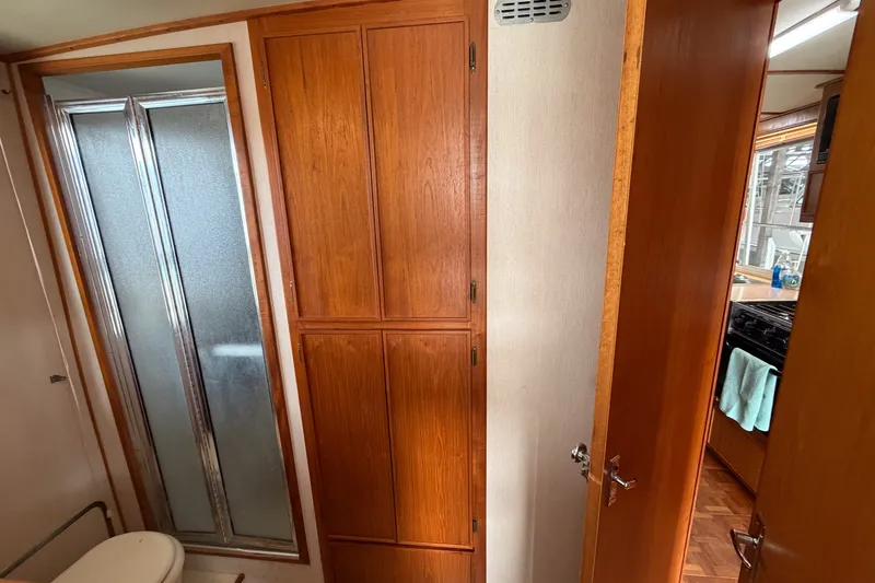 Slide: The Image of 1990 Cruise-A-Home Corsair interior with wooden cabinets and shower area. - 36