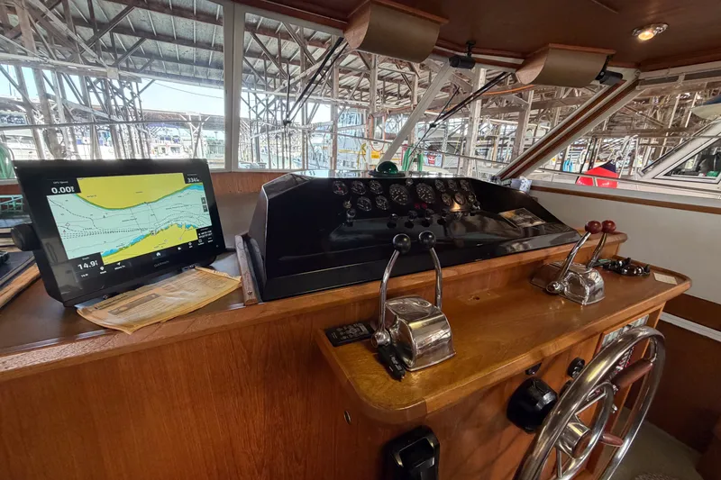 Slide: The Image of 1990 Cruise-A-Home Corsair helm with navigation screen and control levers. - 48