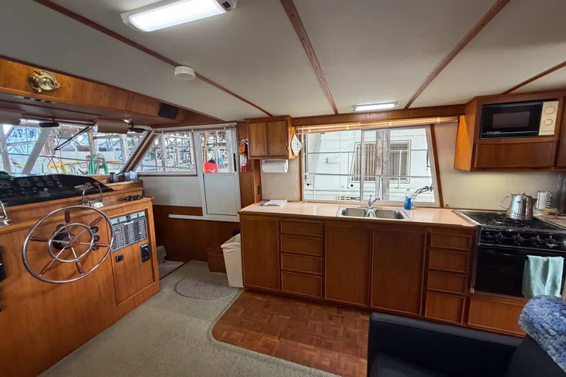 Slide: The Image of Interior of a 1990 Cruise-A-Home Corsair boat with wooden cabinetry and helm. - 54