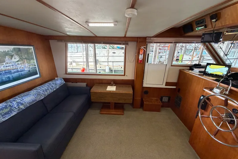 Slide: The Image of Interior of 1990 Cruise-A-Home Corsair with sofa, table, and helm station. - 52