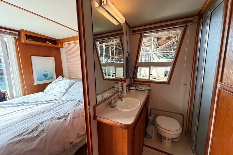 Slide: The Image of 1990 Cruise-A-Home Corsair interior with bedroom and bathroom, featuring wood paneling and nautical decor. - 29