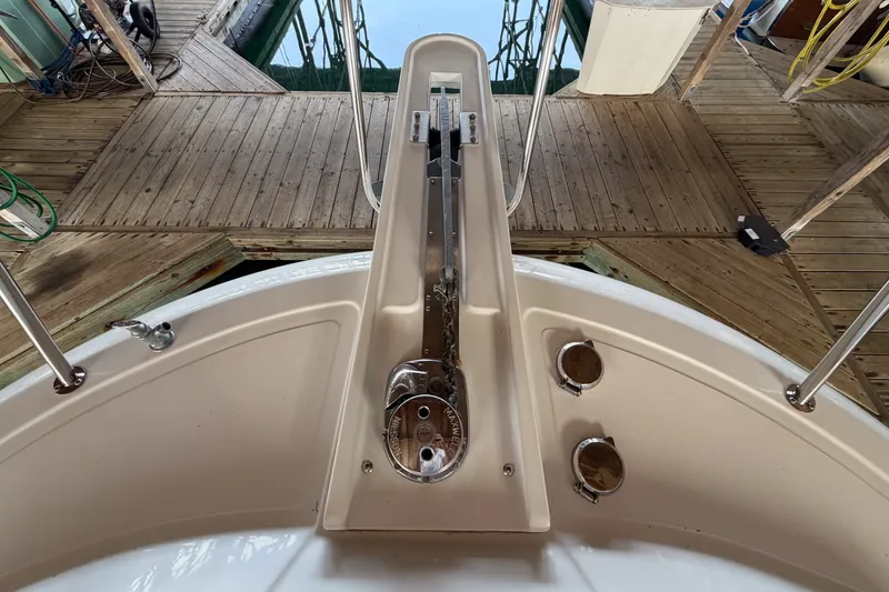 Slide: The Image of 1990 Cruise-A-Home Corsair boat deck with anchor mechanism and wooden dock. - 70