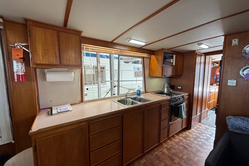 Slide: The Image of Interior of 1990 Cruise-A-Home Corsair with wooden cabinetry and kitchen amenities. - 55