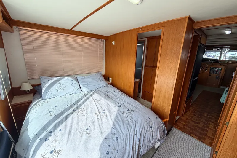Slide: The Image of Cozy bedroom interior of a 1990 Cruise-A-Home Corsair boat with wooden paneling. - 30