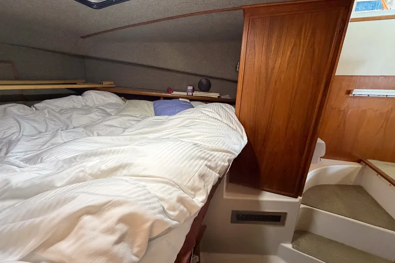 Slide: The Image of Cozy cabin interior of 1990 Cruise-A-Home Corsair with bed and wooden cabinetry. - 64