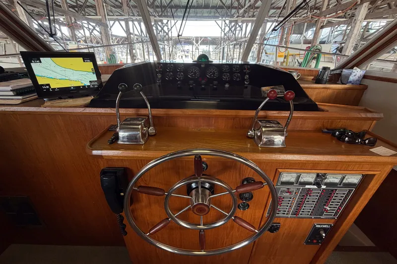 Slide: The Image of 1990 Cruise-A-Home Corsair helm with navigation equipment and wooden steering wheel. - 47