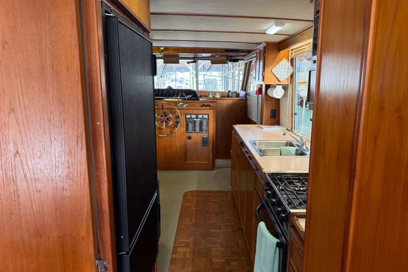 Slide: The Image of Interior of 1990 Cruise-A-Home Corsair boat with kitchen and steering area. - 42