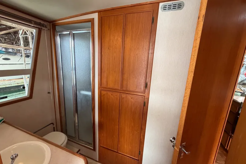 Slide: The Image of 1990 Cruise-A-Home Corsair bathroom with wooden cabinets and shower. - 33
