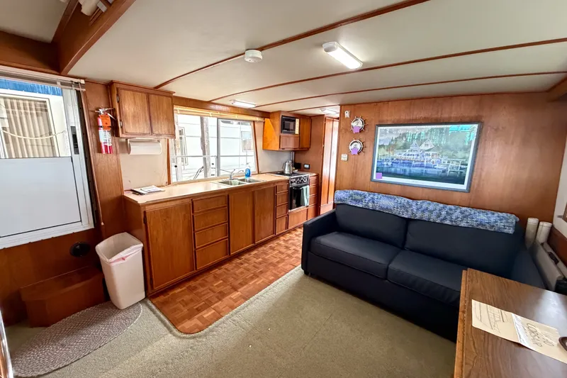 Slide: The Image of Interior of a 1990 Cruise-A-Home Corsair houseboat with kitchen and seating area. - 40