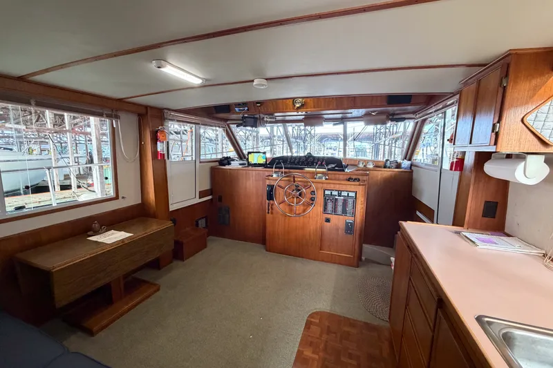 Slide: The Image of Interior of 1990 Cruise-A-Home Corsair boat with wooden helm and seating area. - 45