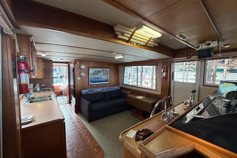 Slide: The Image of Interior of a 1990 Cruise-A-Home Corsair boat with kitchen and seating area. - 60