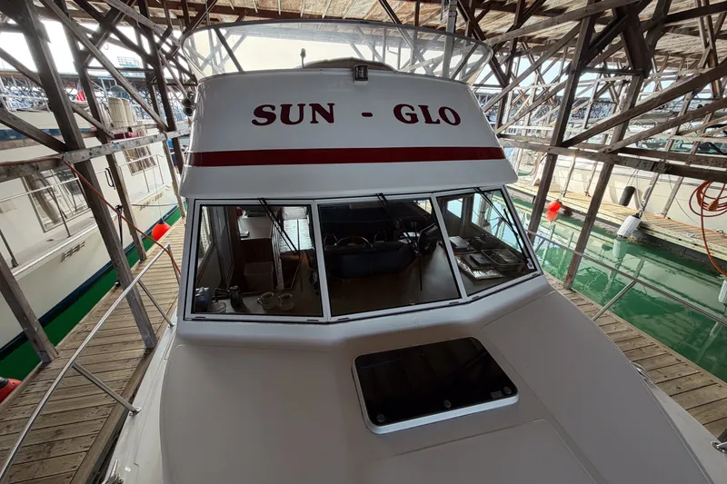 Slide: The Image of 1990 Cruise-A-Home Corsair boat named "Sun-Glo" docked in a marina. - 71