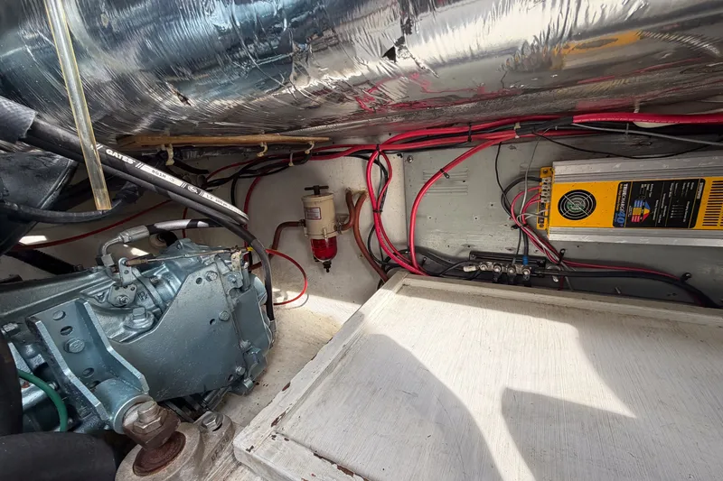 Slide: The Image of Engine compartment of a 1990 Cruise-A-Home Corsair with wiring and mechanical components. - 21