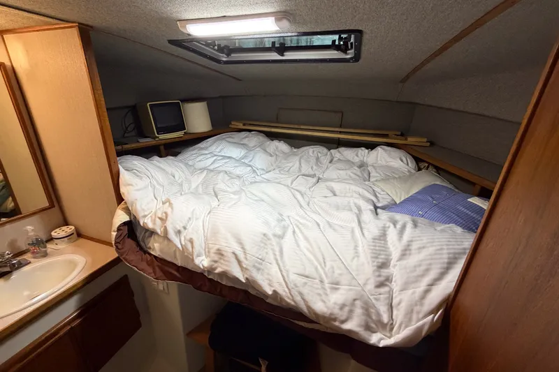 Slide: The Image of Cozy cabin interior of 1990 Cruise-A-Home Corsair with bed and sink. - 62