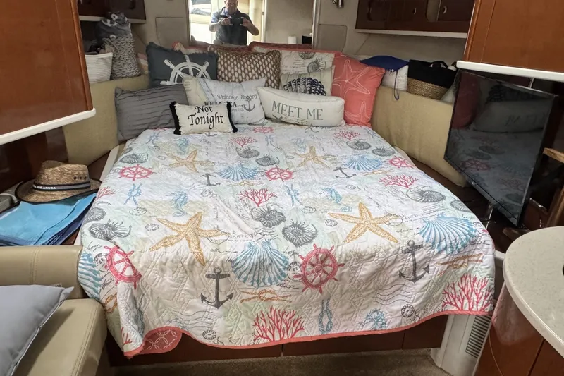 Slide: The Image of Cozy cabin interior of 2008 Sea Ray 290 Sundancer with nautical-themed bedding. - 13