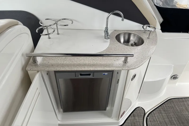 Slide: The Image of 2008 Sea Ray 290 Sundancer boat kitchenette with sink, countertop, and mini fridge. - 10