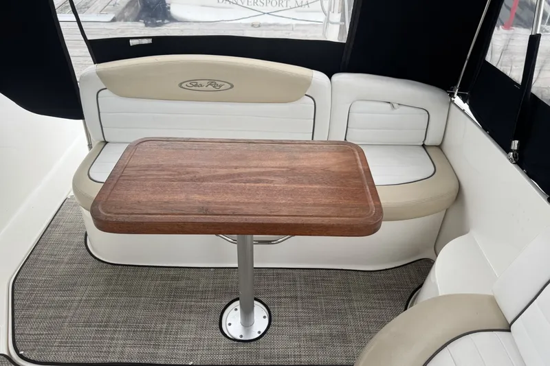 Slide: The Image of Interior of 2008 Sea Ray 290 Sundancer with wooden table and cushioned seating. - 9