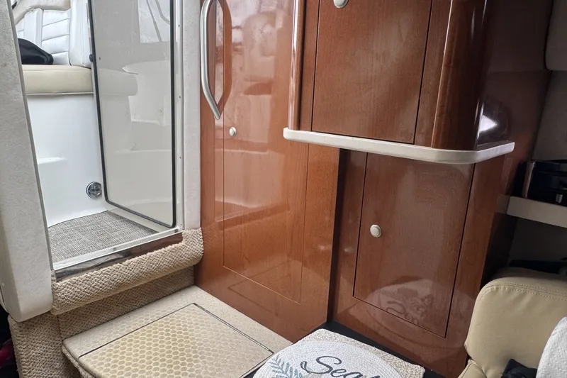 Slide: The Image of Interior of 2008 Sea Ray 290 Sundancer with wooden cabinetry and carpeted steps. - 14