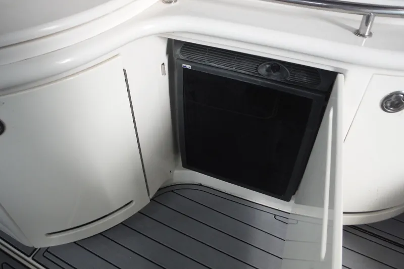 Slide: The Image of 2007 Sea Ray 290 SLX boat interior with open cabinet and black appliance. - 24