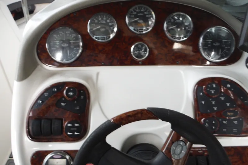 Slide: The Image of Dashboard of a 2007 Sea Ray 290 SLX boat with wood grain finish and gauges. - 22