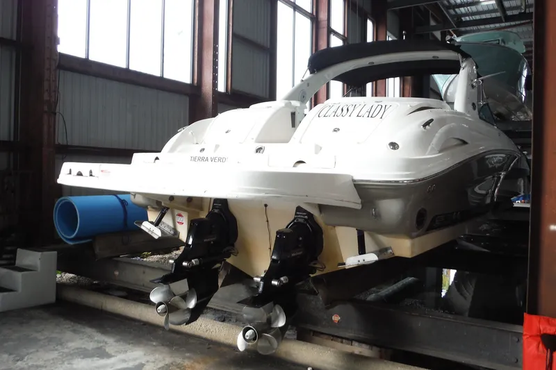 Slide: The Image of 2007 Sea Ray 290 SLX boat in storage, rear view with dual propellers. - 2