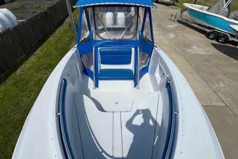 Slide: The Image of 2000 Hydra-Sports boat with blue canopy and seating, docked on concrete. - 11