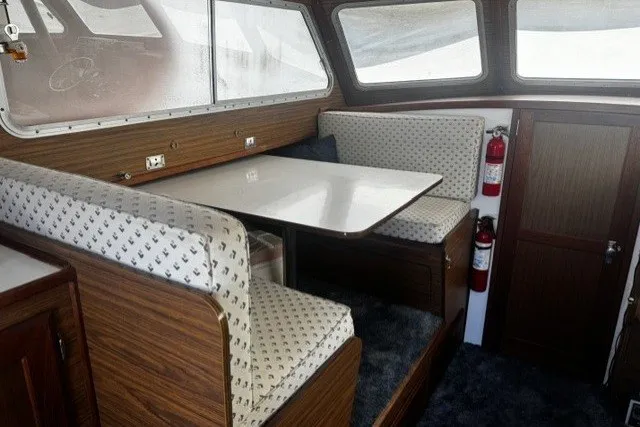 Slide: The Image of 1972 Luhrs 32 Convertible boat interior with dining area, wood paneling, and fire extinguishers. - 6
