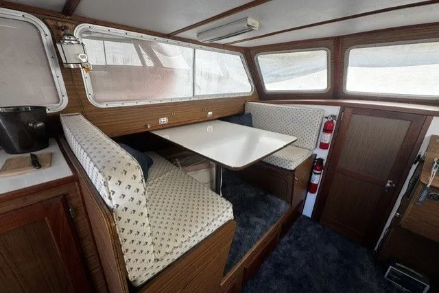 Slide: The Image of Interior of 1972 Luhrs 32 Convertible boat with dining area and wooden accents. - 8