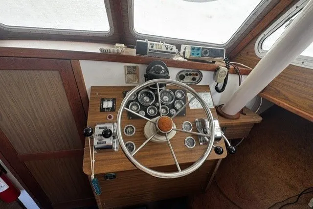Slide: The Image of 1972 Luhrs 32 Convertible boat helm with vintage steering wheel and control panel. - 11
